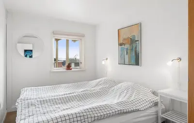 a white bedroom with a bed and a window at Nice Home In Øster Assels in Øster Assels