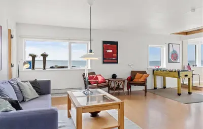 a living room with a couch and a table at Nice Home In Øster Assels in Øster Assels