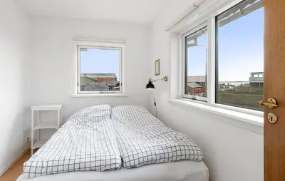 a white bedroom with a bed and two windows at Nice Home In Øster Assels in Øster Assels