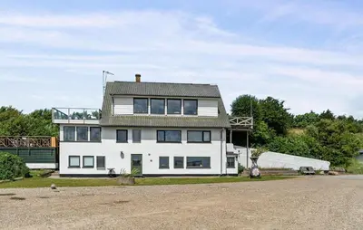 a white house with a roof on top of it at Nice Home In Øster Assels in Øster Assels