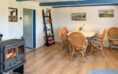 a dining room with a table and a wood stove at 1 Bedroom Gorgeous Home In Spøttrup in Spottrup