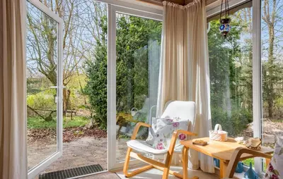 a room with a window and a chair and a table at 3 Bedroom Stunning Home In Spøttrup in Spottrup