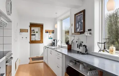 a kitchen with white counters and a sink and a window at 2 Bedroom Stunning Home In Øster Assels in Øster Assels