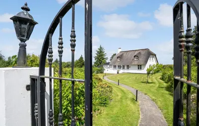 an open gate with a white house in the background at Stunning Home In Fjerritslev With Sauna in Fjerritslev