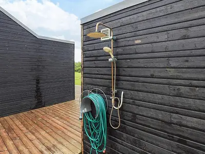 a hose hooked up to the side of a wooden wall at 4 star holiday home in Brovst in Brovst