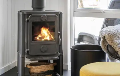 a wood stove in a living room with a fire at Stunning Home In Hurup Thy With Sauna in Sønder Ydby