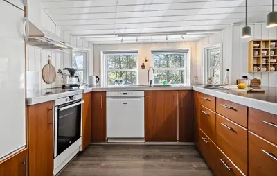 a large kitchen with wooden cabinets and white appliances at Stunning Home In Hurup Thy With Sauna in Sønder Ydby