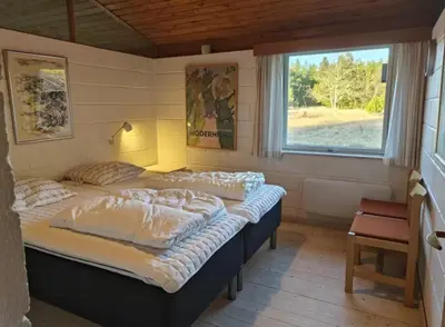 two beds in a room with a window at Dune House Near Bulbjerg in Frøstrup