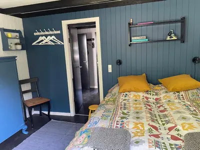 a bedroom with a bed and a blue wall at Cozy Holiday Home With Forest And Fjord Views in Roslev