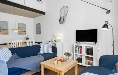 a living room with a blue couch and a tv at Stunning Home In Vestervig With Sauna in Vestervig