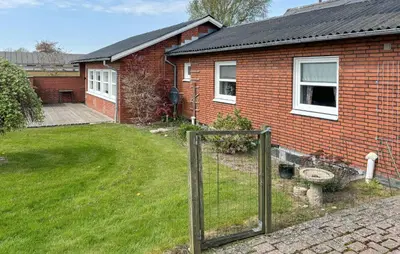 a brick house with a fence in the yard at Gorgeous Home In Spøttrup With Wifi in Spottrup