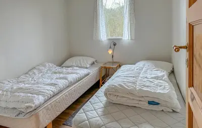 two beds in a small room with a window at Lovely Home In Fjerritslev With Wifi in Fjerritslev