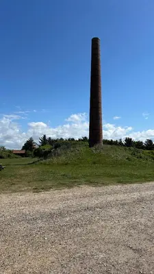a brick tower sitting on top of a field next to a gravel road at Bright Nordic Loft Apartment in Spottrup