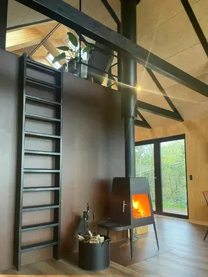 a living room with a fireplace in a house at Modern Wooden House Near Halkær Bredning in Nibe