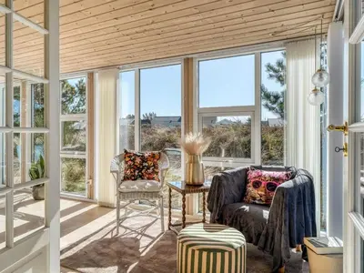 a screened in porch with two chairs and a table at Holiday Home Mynthe - 500m from the sea by Interhome in Thisted