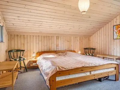 a bedroom with a bed in a wooden room at Holiday Home Franzisca - 200m to the fjord by Interhome in Roslev