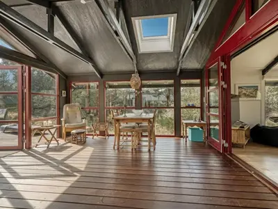 a dining room with a table and some windows at Holiday Home Nimrod - 800m from the sea by Interhome in Blokhus