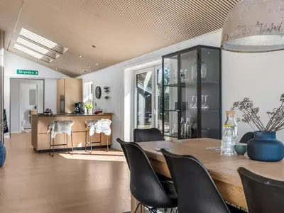 a dining room with a wooden table and black chairs at Holiday Home Heidl - 2km from the sea by Interhome in Blokhus