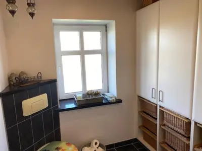 a kitchen with a window and a shelf and a window at Dejlig gårdhave 5 soveværelser in Harboør
