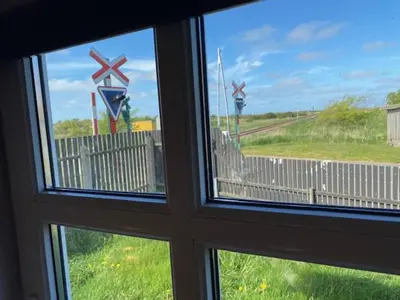 a window looking out at a view of a train yard at Dejlig gårdhave 5 soveværelser in Harboør