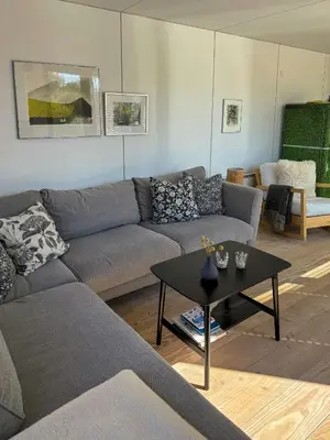 a living room with a couch and a table at Modern Holiday Home By Limfjord in Øster Assels