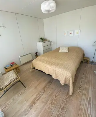 a bedroom with a bed and a wooden floor at Modern Holiday Home By Limfjord in Øster Assels
