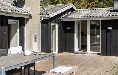 a wooden deck with a table and chairs on it at 3 Bedroom Pet Friendly Home In Løkken in Løkken