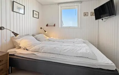 a large white bed in a bedroom with a television at 3 Bedroom Gorgeous Home In Lemvig in Lemvig
