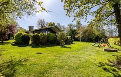 a house on a lawn with a swing at 3 Bedroom Nice Home In Farsø in Farsø