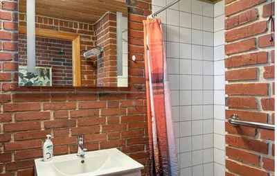 a bathroom with a sink and a brick wall at Nice Home In Roslev With Wifi in Roslev