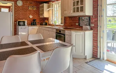 a kitchen with a table and chairs and a brick wall at Nice Home In Roslev With Wifi in Roslev