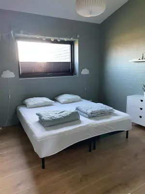a bedroom with a bed with two pillows and a window at Moderne bynært hus in Holstebro