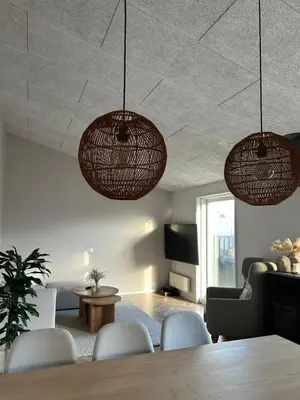 a living room with two hanging lights and a table at Nyrenoveret,hyggeligt og centralt hus in Holstebro