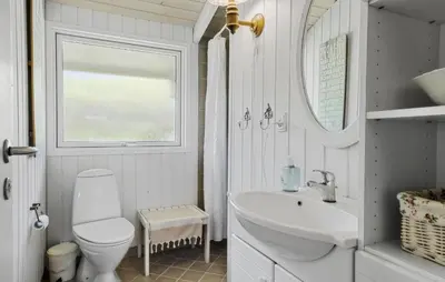a bathroom with a sink and a toilet and a window at 3 Bedroom Beautiful Home In Blokhus in Blokhus