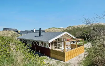 a house sitting on the sand in the desert at 3 Bedroom Beautiful Home In Blokhus in Blokhus