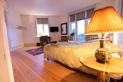 a bedroom with a bed with a lamp on a table at Lejlighed i Holstebro gågade in Holstebro