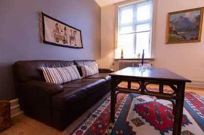 a living room with a leather couch and a table at Lejlighed i Holstebro gågade in Holstebro