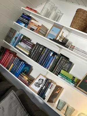 a book shelf filled with lots of books at Cozy big apartment in Blokhus