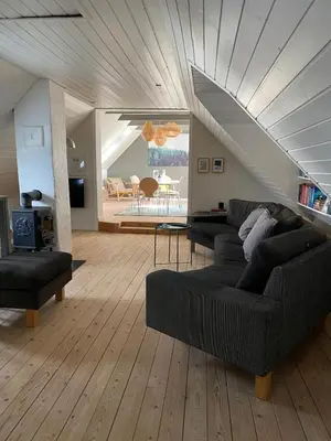 a living room with two couches and a staircase at Cozy big apartment in Blokhus