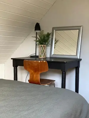 a bedroom with a desk with a mirror and a chair at Cozy big apartment in Blokhus