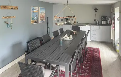 a dining room with a black table and chairs at Cozy Home In Thyborøn With Wifi in Thyborøn