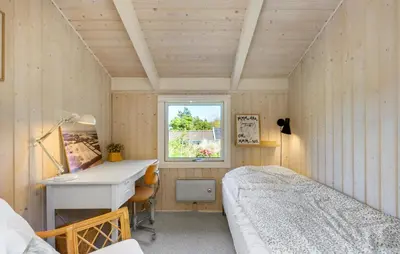a room with two beds and a desk and a window at 3 Bedroom Beautiful Home In Blokhus in Blokhus