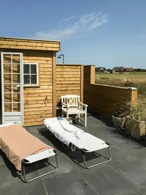 a patio with two beds and a shed at Charmerende Villa Havly Nær Vesterhavet in Harboør