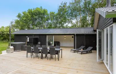 a patio with a table and chairs on a deck at 3 Bedroom Stunning Home In Spøttrup in Spottrup