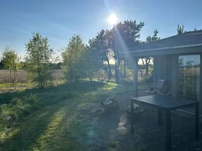 a picnic table and a fire pit in a yard at Summer House With Fields And Fjord Views in Thyholm