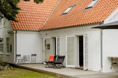 an outdoor patio with chairs and an orange roof at Lovely House Near Nature For Relaxation in Fjerritslev
