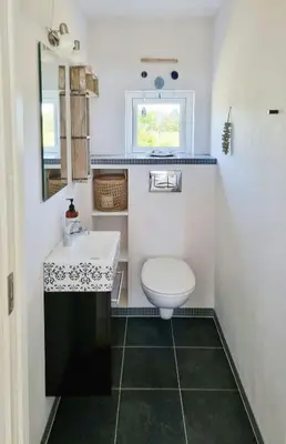 a small bathroom with a toilet and a sink at Modern House Close To The North Sea in Tranum