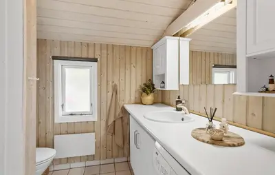 a bathroom with a sink and a toilet at 3 Bedroom Stunning Home In Blokhus in Blokhus