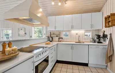a white kitchen with white cabinets and a sink at 3 Bedroom Stunning Home In Blokhus in Blokhus