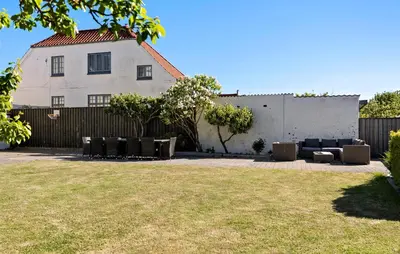 a yard with chairs and a fence and a building at Nice Home In Løgstør With Wifi in Løgstør